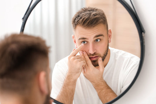 man inserts contact lens